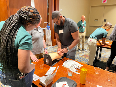 A faculty member works with a medical student during a hands-on skills workshop