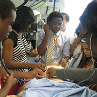 A group of students practice hands on skills during a simulation activity